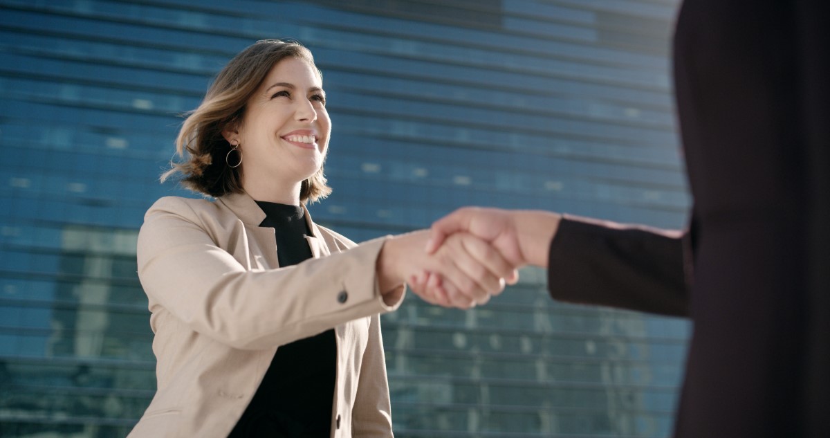 két nő kezet fog az utcán