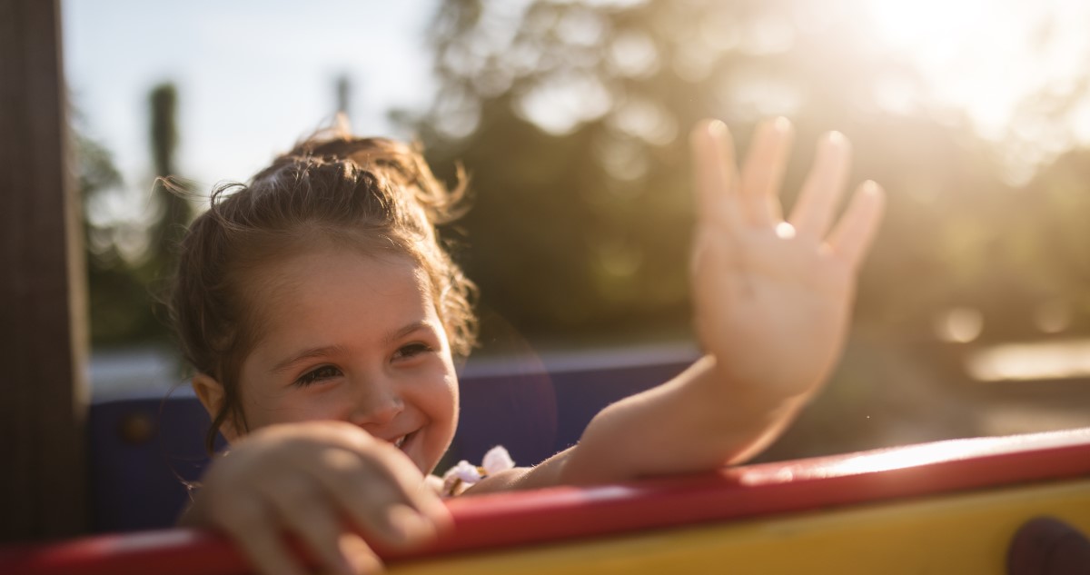 kislány integet a játszótéren