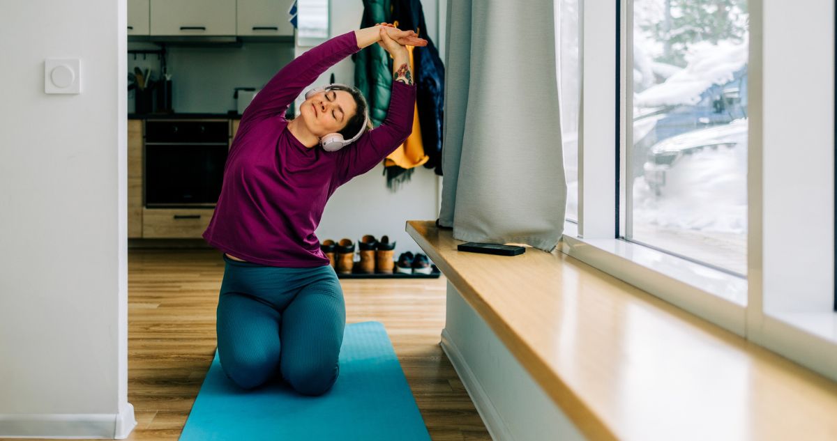 nő otthon tornázik jógaszőnyegen