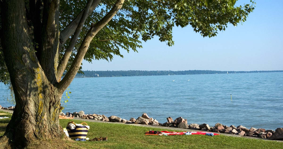 balatoni strand napozó törölközővel, strandtáskával a parton