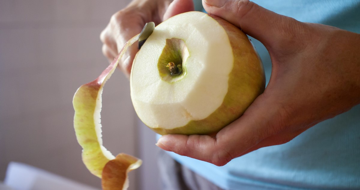 alma-hamozas - Gyerekszoba A képen egy nő keze látható, amiben egy almát tart, amit éppen hámoz.
