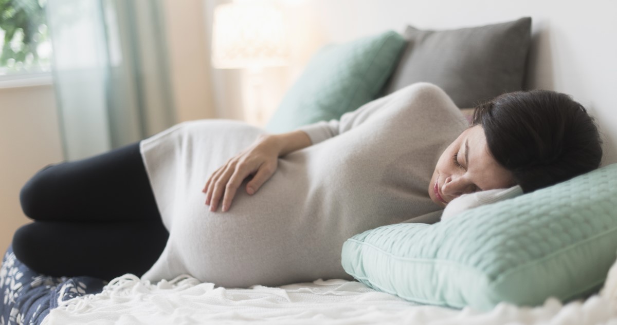kismama-alszik - Gyerekszoba A képen egy várandós kismama alszik délután a kanapén.